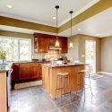 Luxury kitchen interior with green walls and stone floor.