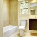 New modern yellow bathroom with beige tiles.